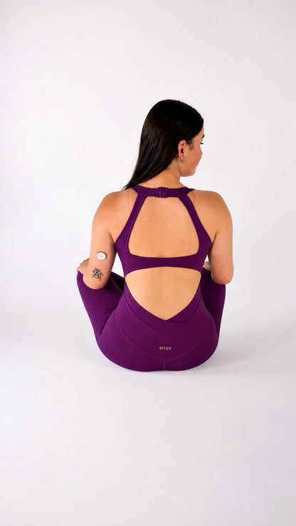 Back view of a woman in a purple jumpsuit, showcasing the stylish cut of the Luna Jumpsuit.