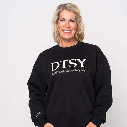 Woman wearing the DTSY Jumper 'Caution: May suddenly invert', showcasing the Aerialist Jumper design and comfort.
