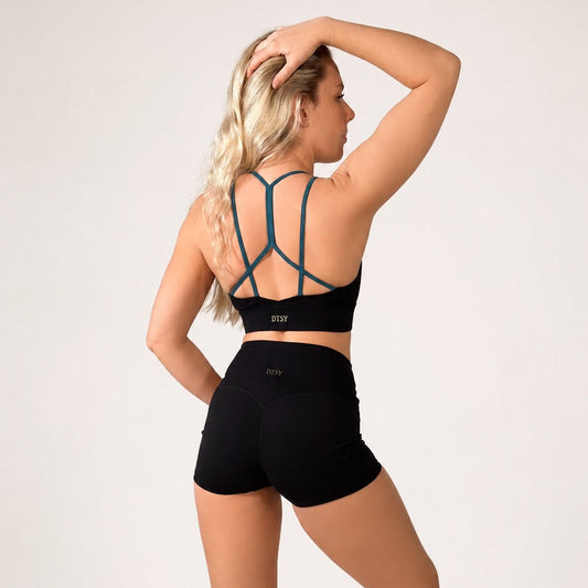 Woman wearing 'Emma' Pole Shorts from the back, showcasing the strappy sports bra and comfortable fit for pole fitness.
